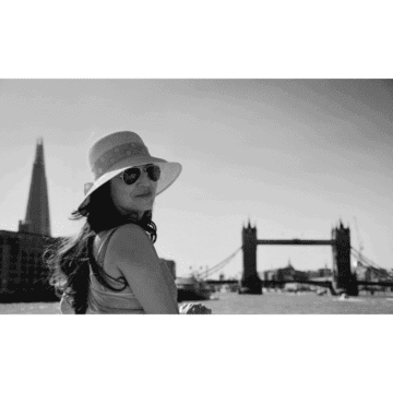 Blog author  looking over her shoulder with tower bridge, London, in the background
