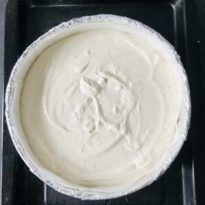 Overhead photograph of the cheesecake filling inside the prepared springform tin, ready for baking