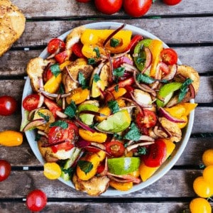 A plate of Panzanella salad on a slatted table.