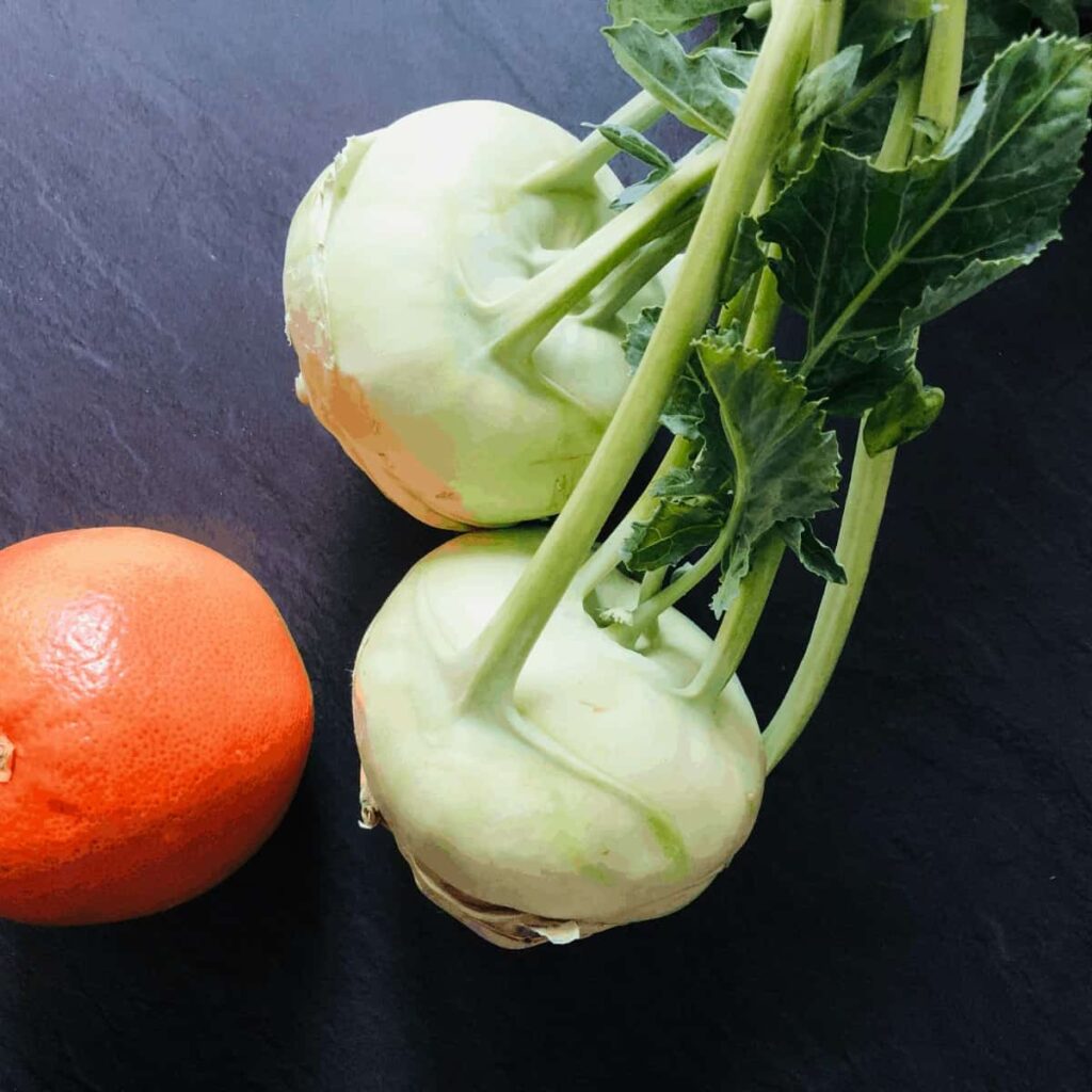 Two whole raw Kohlrabi with a whole grapefruit