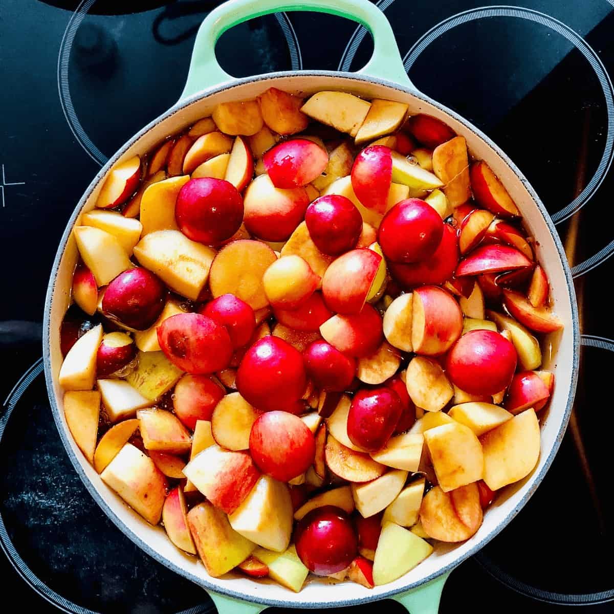 A pot of uncooked sliced crab apples sat on a hob