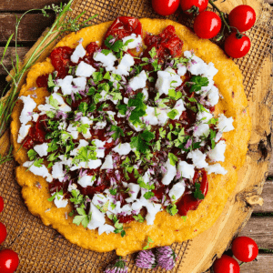 Overhead photograph of baked polenta topped with confit tomatoes and feta.