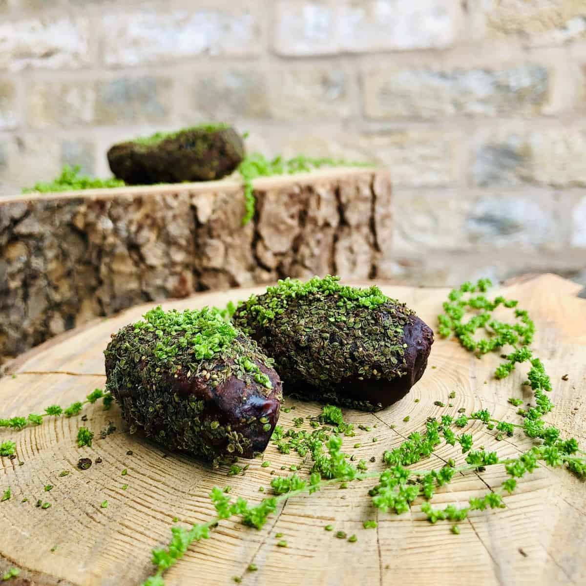 Two stuffed dates covered in nettle seeds.