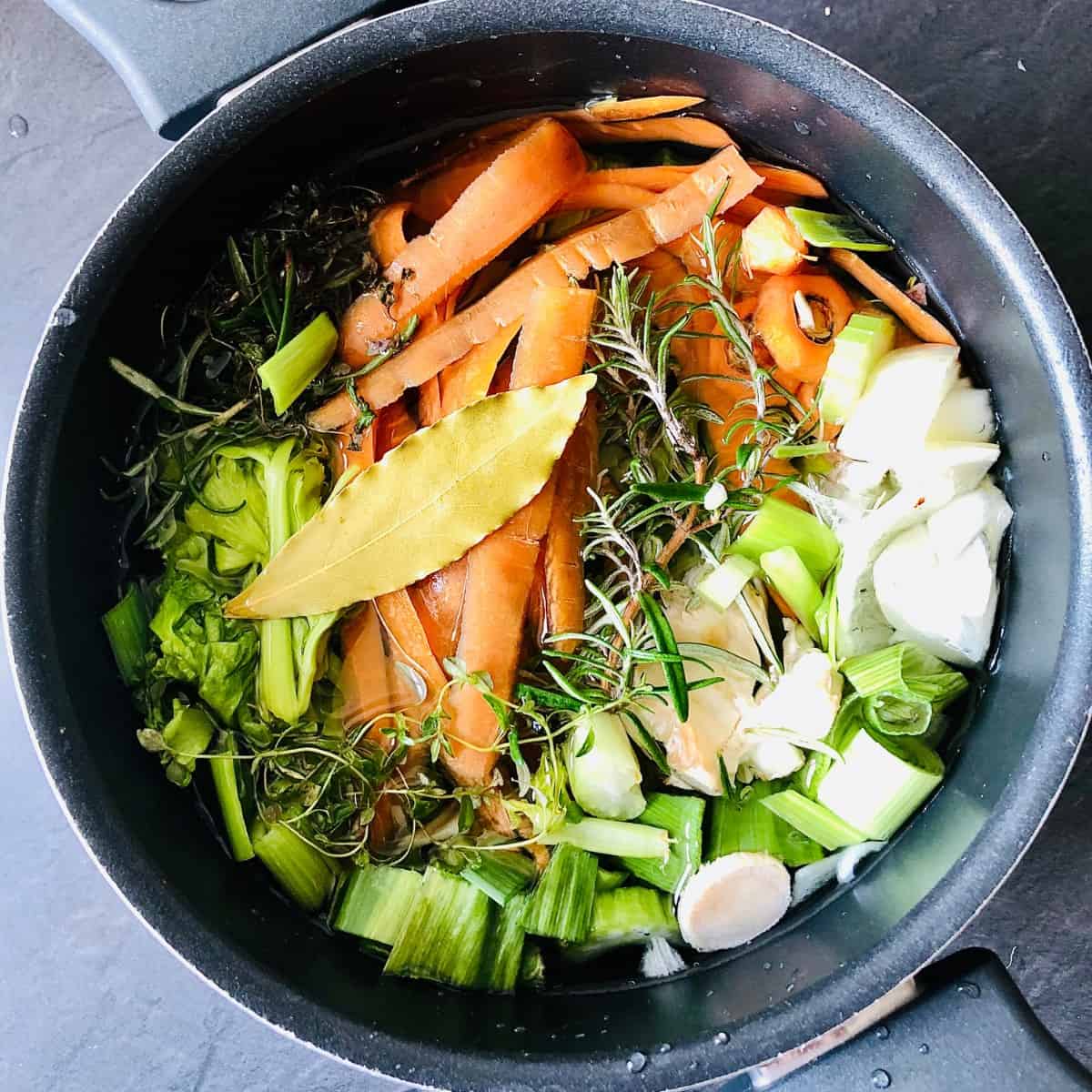 A pot containing vegetable scraps in water ready to make homemade vegetable stock