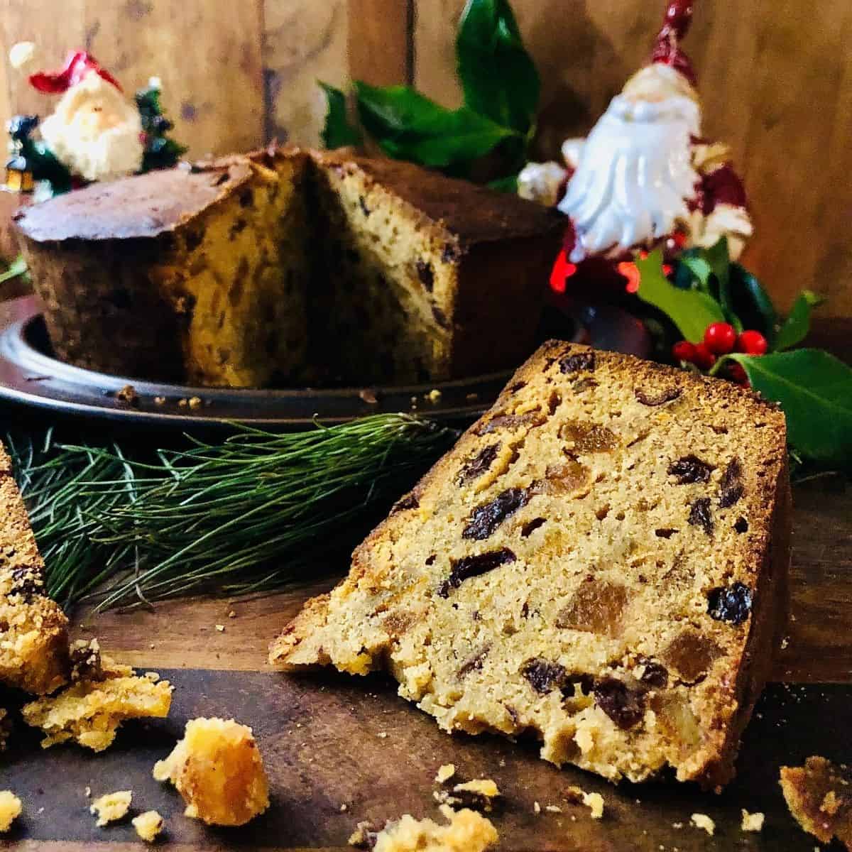 Slice of Christmas cake surrounded by crumbs. 
