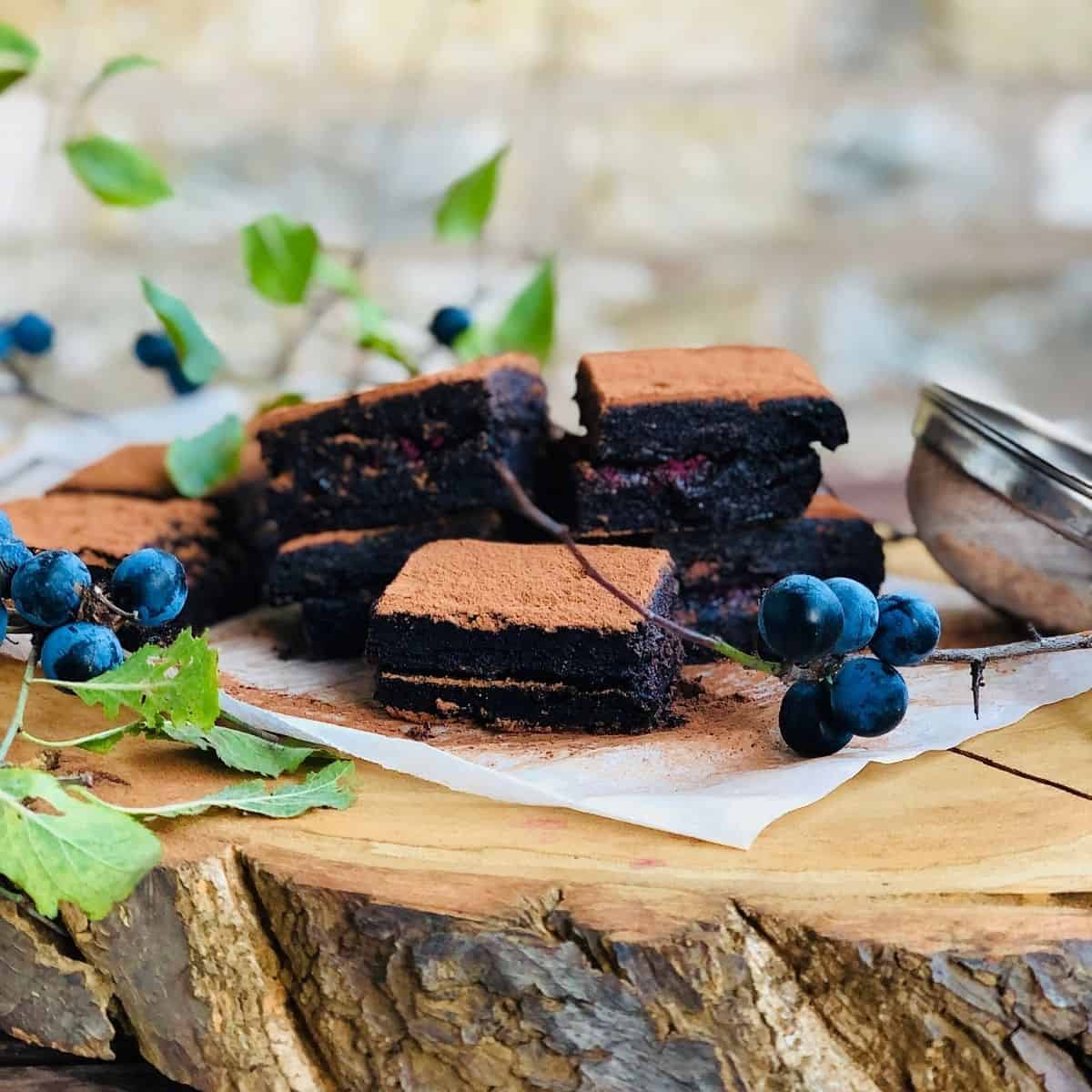 Piles of vegan brownies on a sliced tree trunk platter
