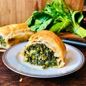 Slice of vegan spinach and feta strudel on a small plate