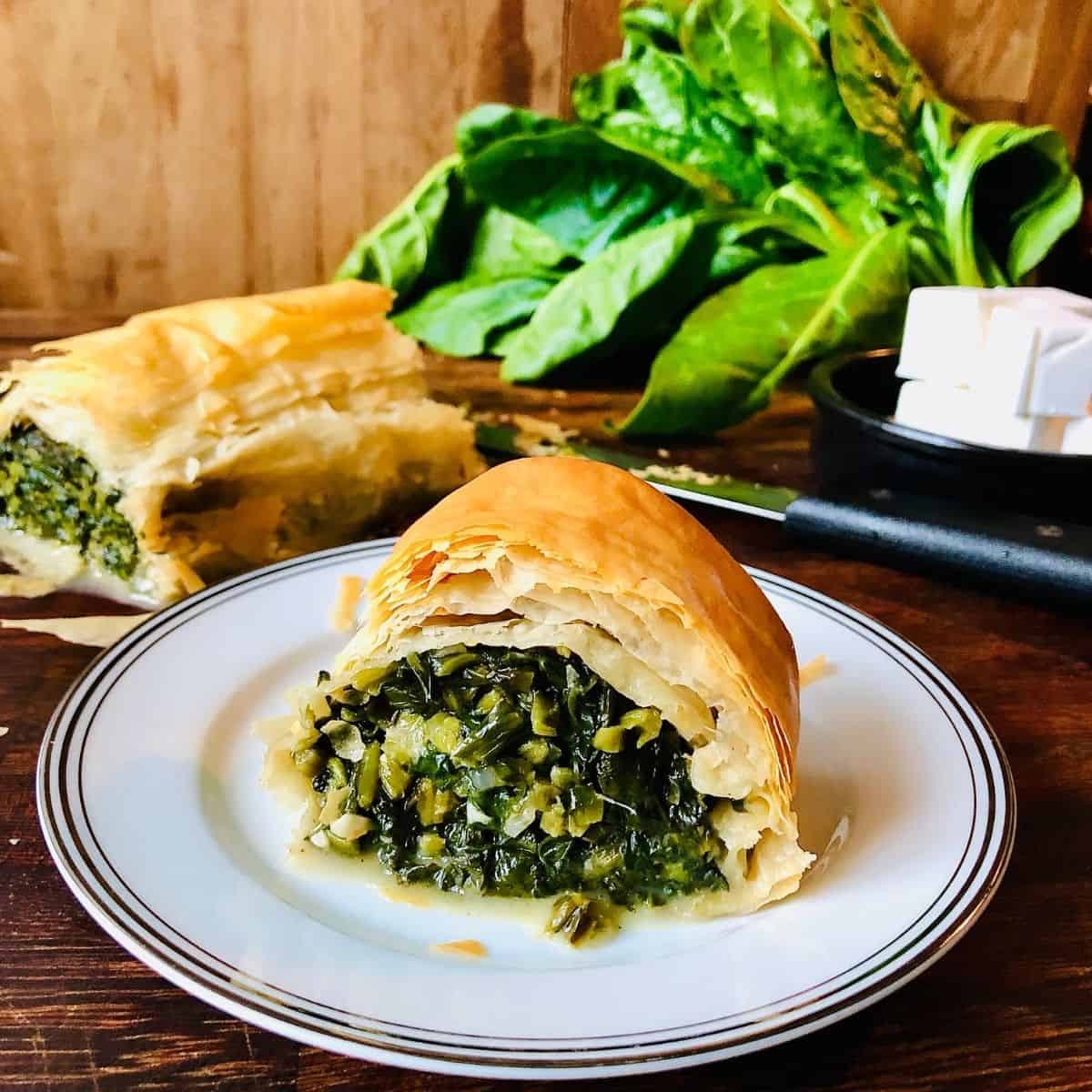 Slice of vegan spinach and feta strudel on a small plate