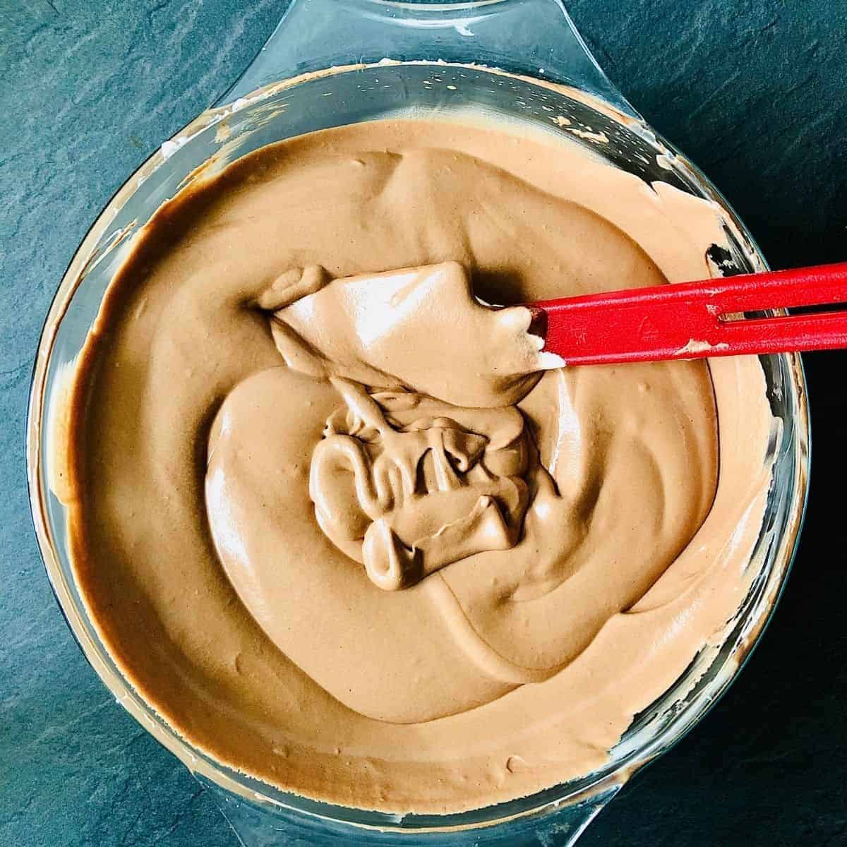 Glass bowl of completely mixed melted chocolate and whipped cream