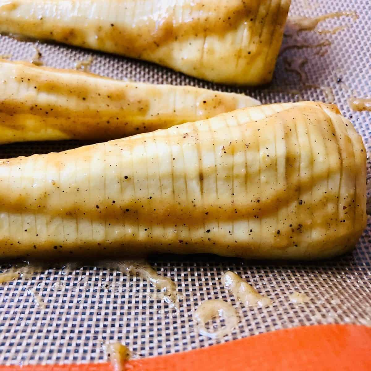 Close up of hassleback parsnip showing maple and miso marinate