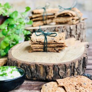 Five Buckwheat crackers tied with green string sat upon a log slice platter.