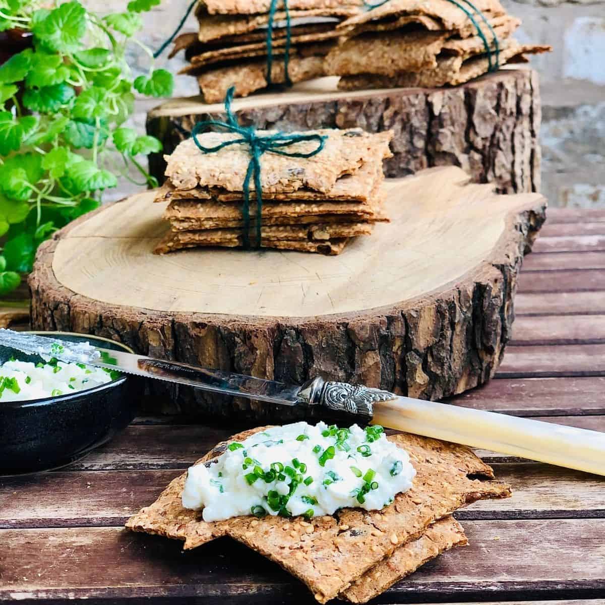 Five Buckwheat crackers tied with green string sat upon a log slice platter
