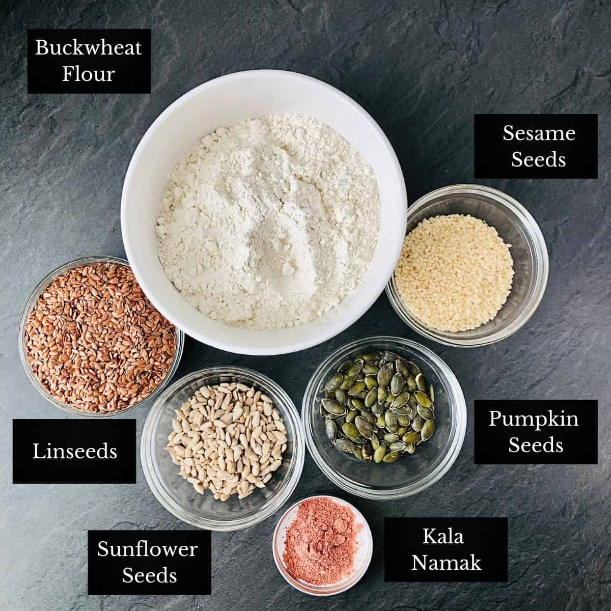 Ingredients for gluten free crackers in small glass bowls. Annotated