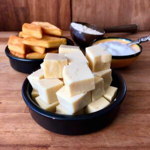 Two shallow dishes containing gram flour paneer. One dish contains fried paneer