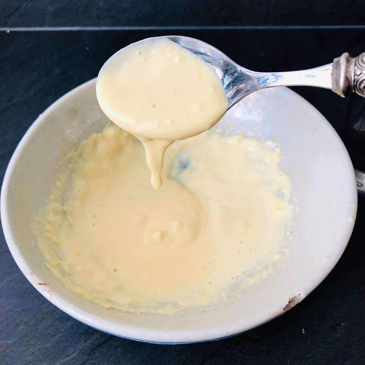 A bowl containing gram flour and yogurt mix for jimmikund gravy