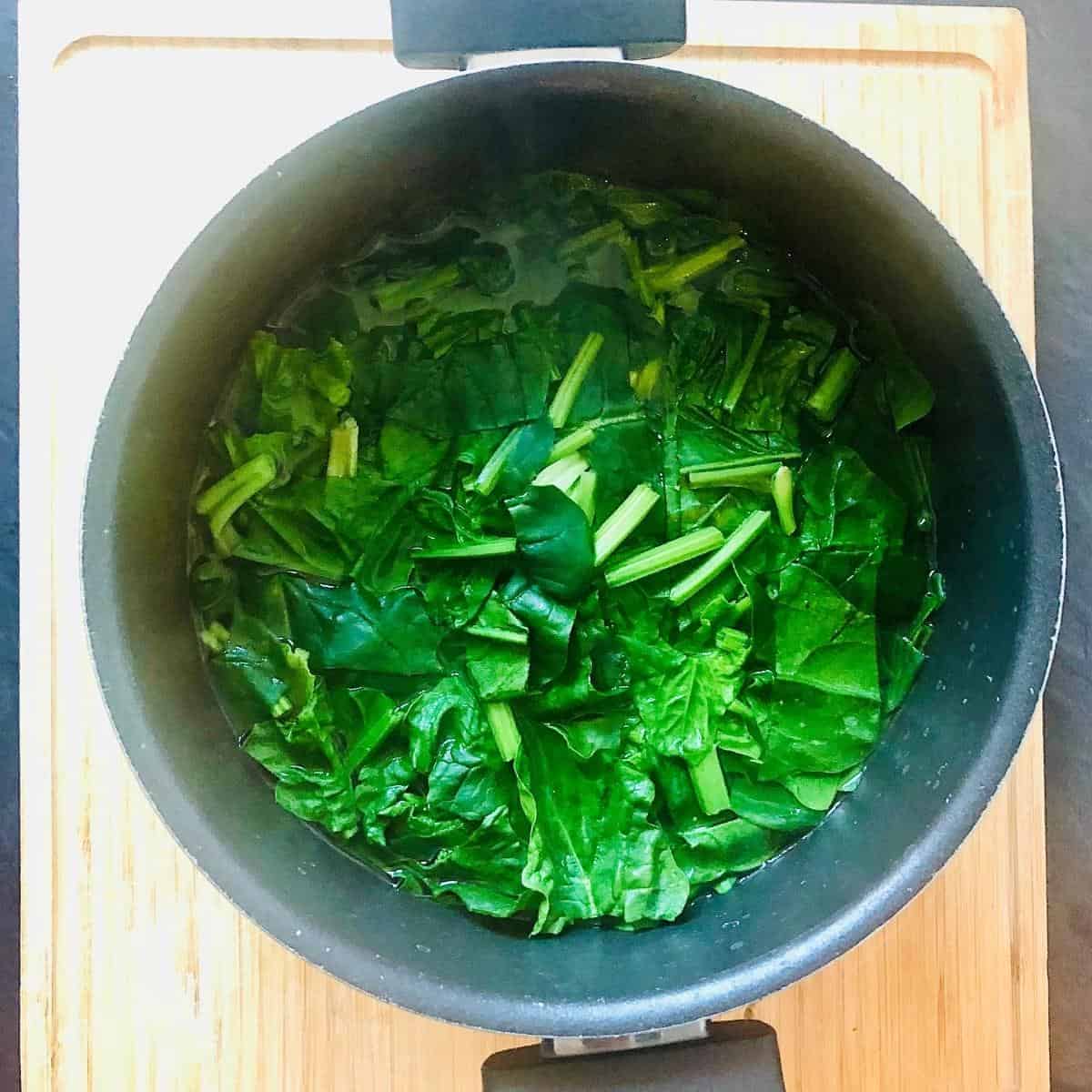A pan of spinach blanched in boiling water