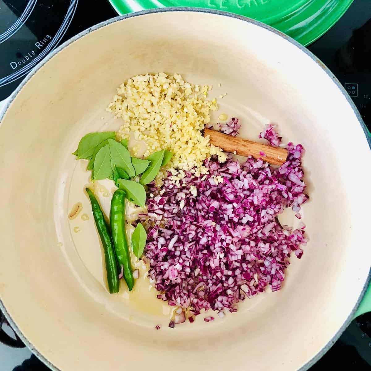 Sautéing finely chopped onions, garlic, ginger, green chilli's, curry leaf and cinnamon stick for ishtew vegetable stew in a ceramic pot.