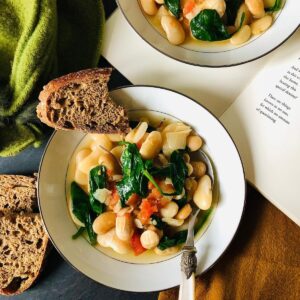 Bowl of butter-bean and baby spinach stew