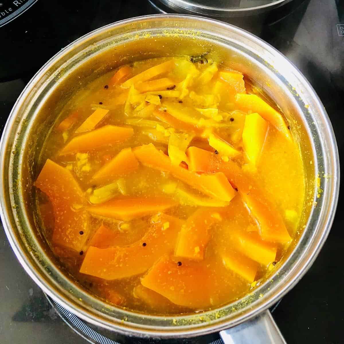 Adding sliced butternut squash to saucepan to Charchari mixed vegetable recipe