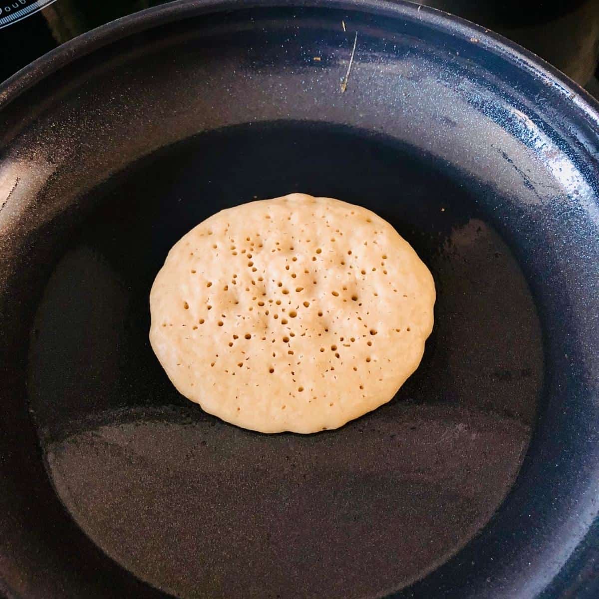 Buckwheat pancake cooking in a frying pan