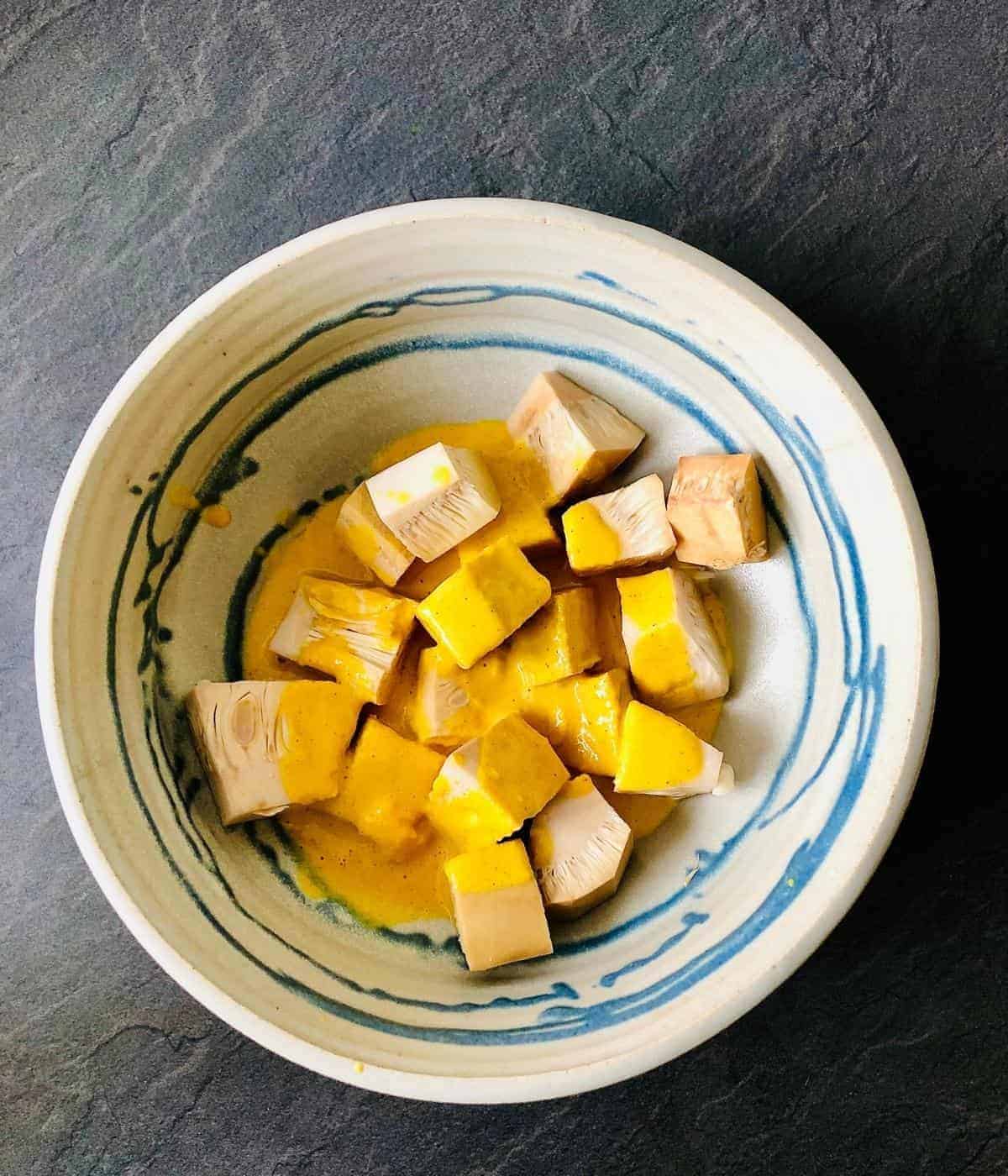 A bowl of jackfruit with marinade poured over.