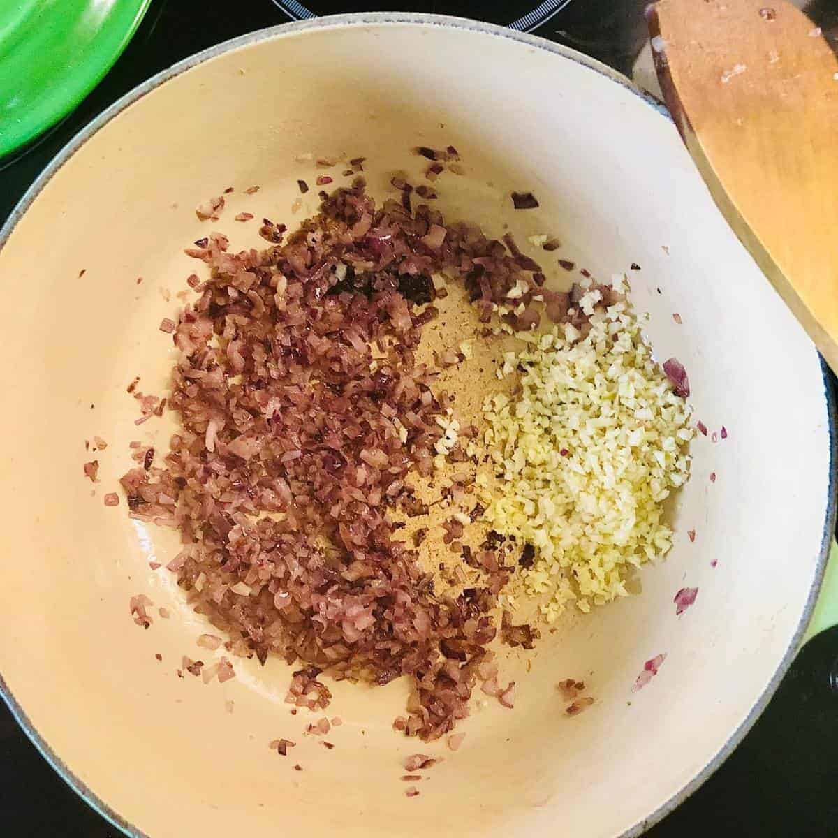 Pot containing finely chopped onion, garlic and ginger
