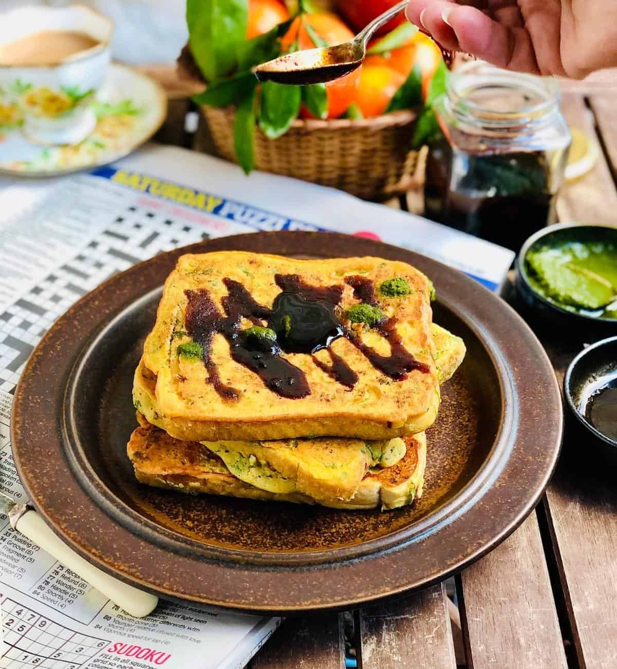 Plate with a pile of three bread pakora topped with chutney