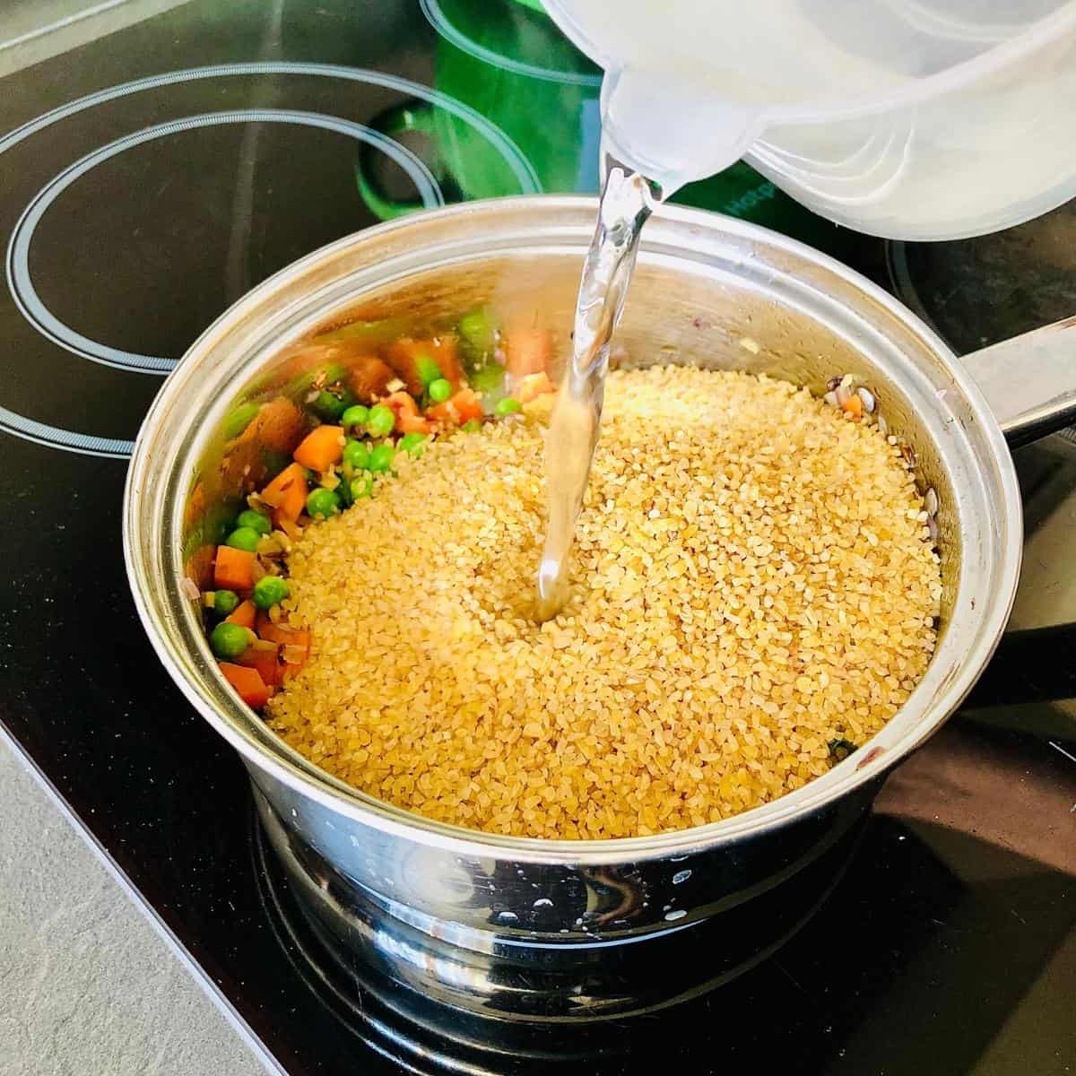 Dalia mix in saucepan, adding the dalia cracked wheat and water