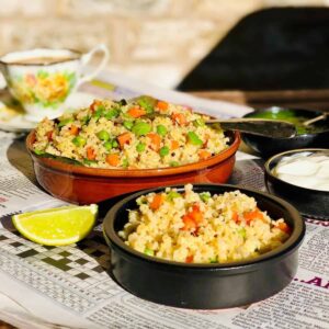 Dalia upma, healthy breakfast, in two shallow bowls.