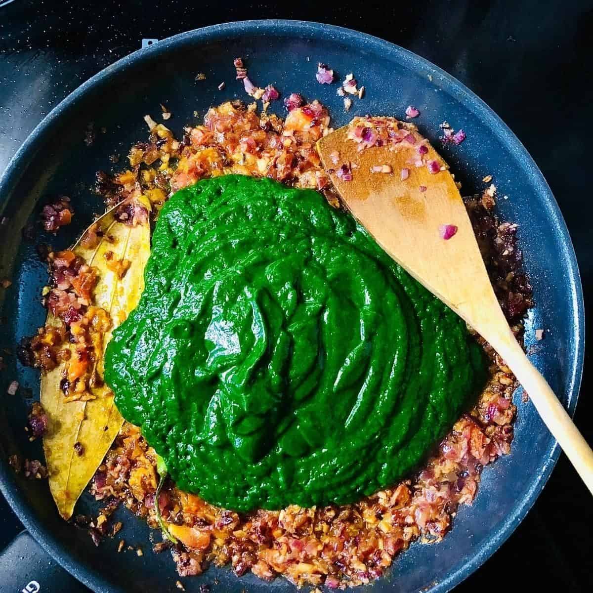 Spinach puree mixed into palak paneer base mix and gram masala added
