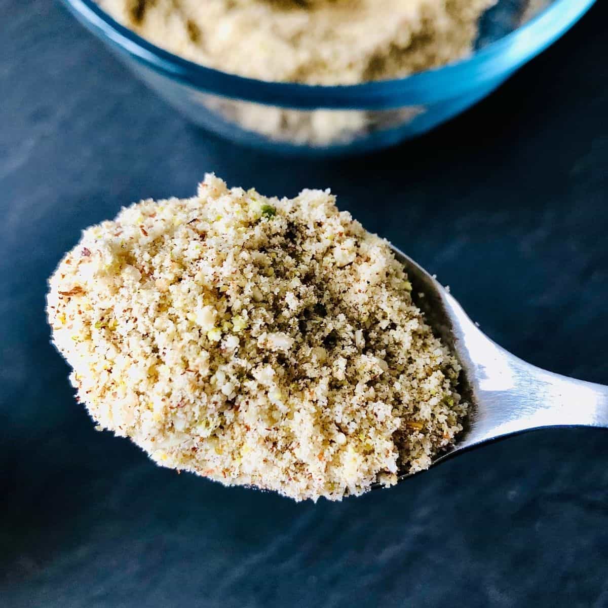 Thandai powder mix on a teaspoon