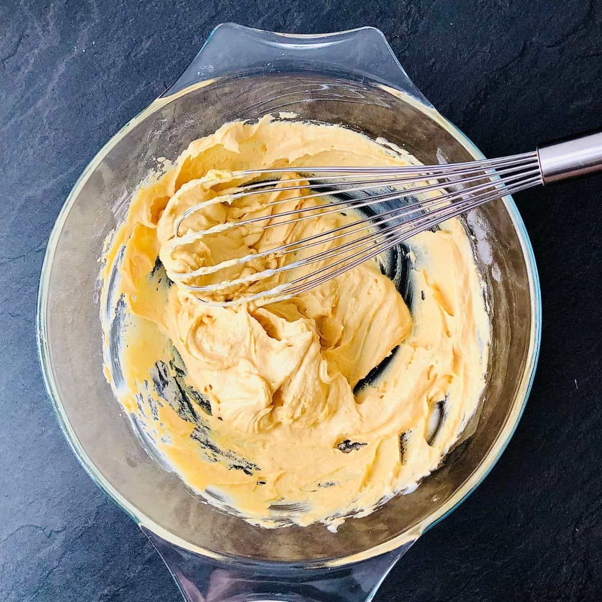 Gram flour and vegan yoghurt whisked to a smooth batter in a glass bowl