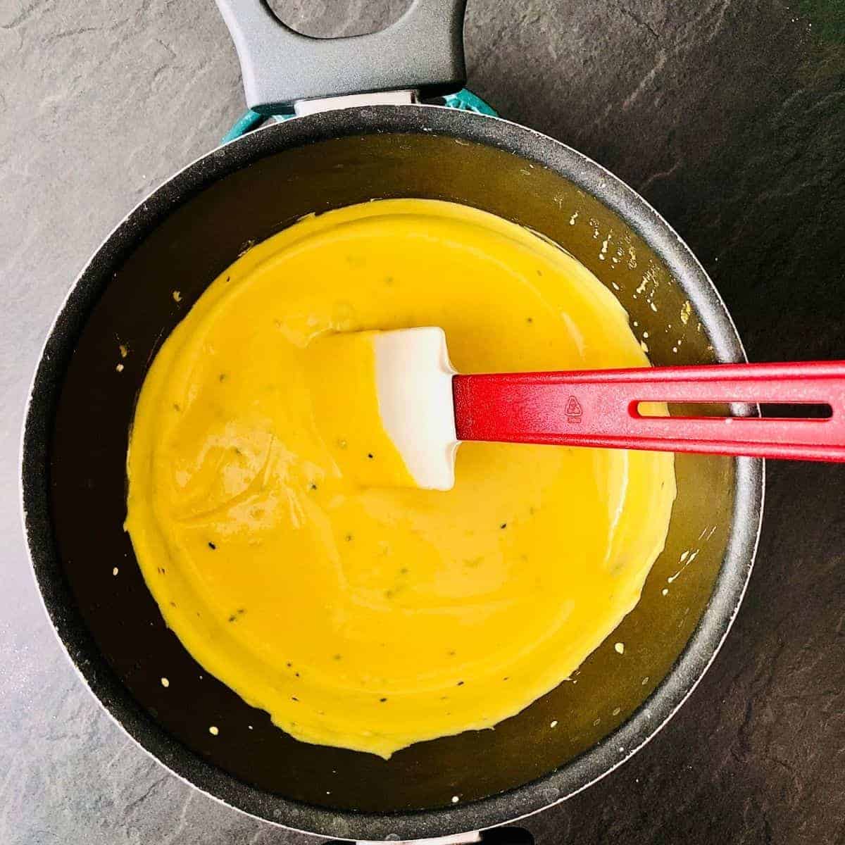 Kadhi mixture in a saucepan after chilli powder, turmeric and gram flour better added