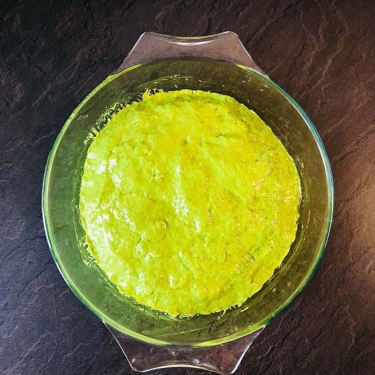 A glass bowl containing wild garlic focaccia dough