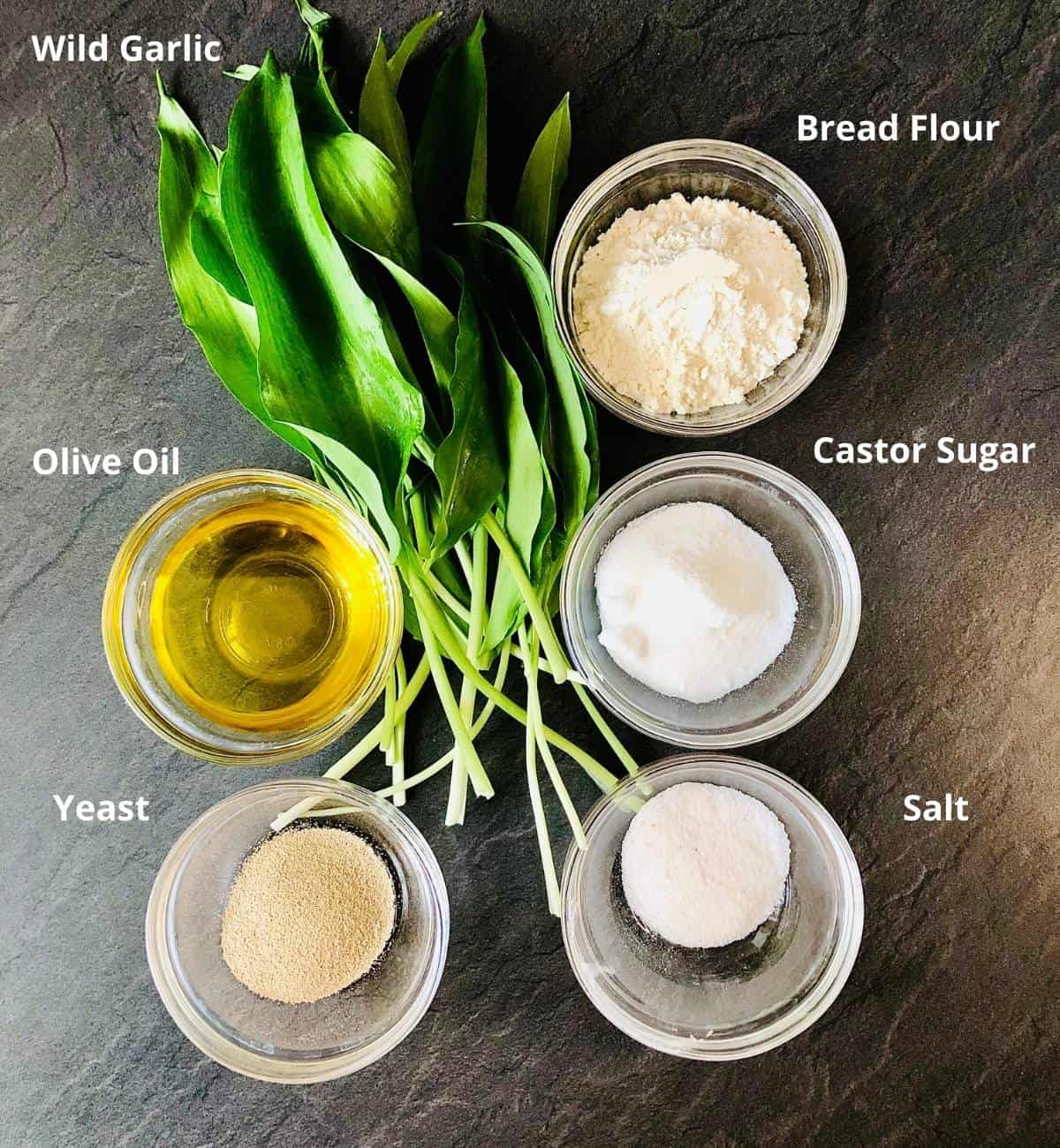 No-knead wild garlic focaccia ingredients in shallow glass dishes. Annotated.