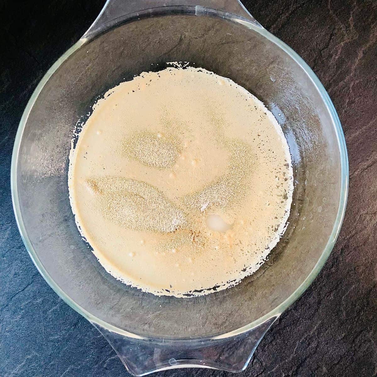 Yeast, castor sugar and water mixed together in a glass bowl