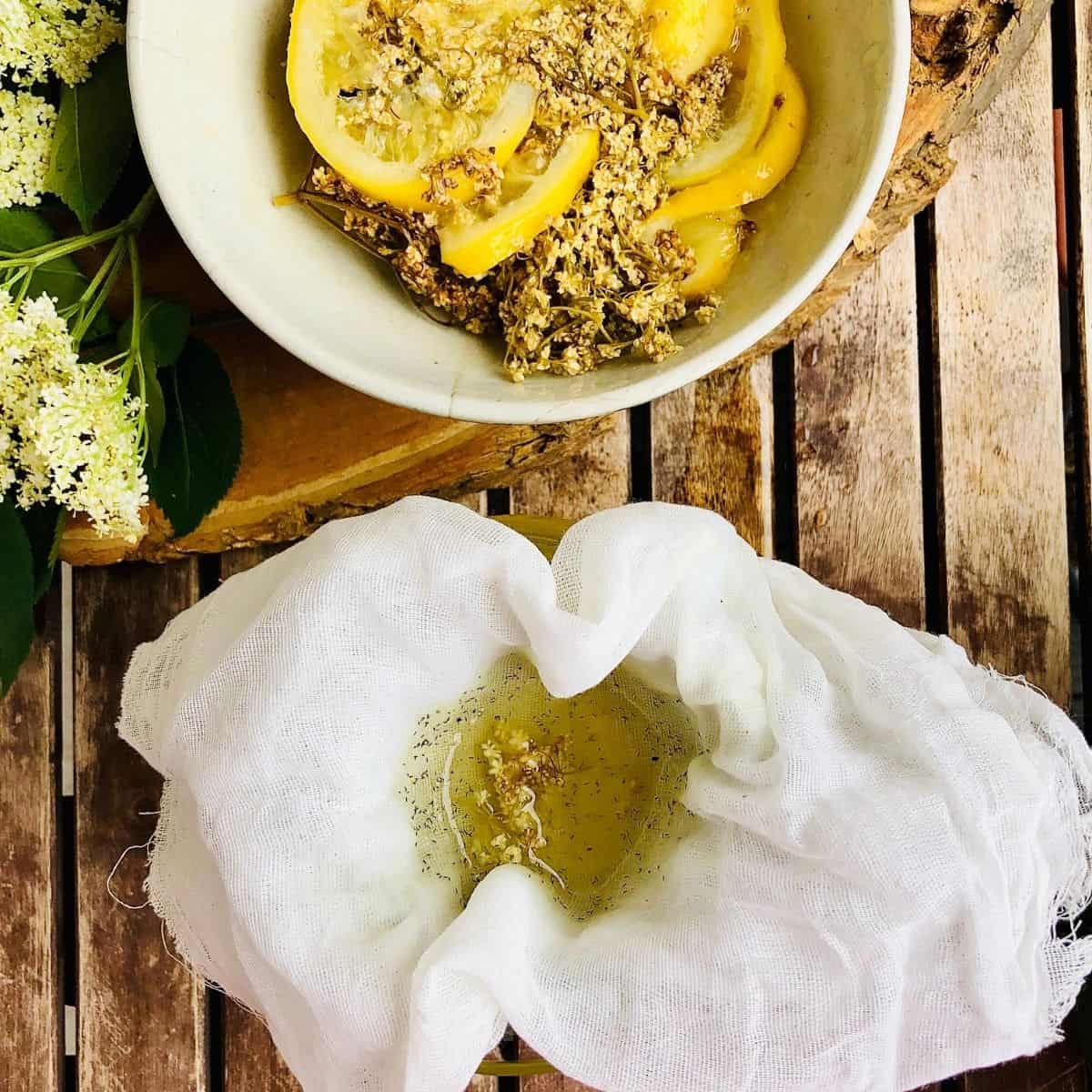 Straining Elderflower cordial through a muslin cloth into a bowl.