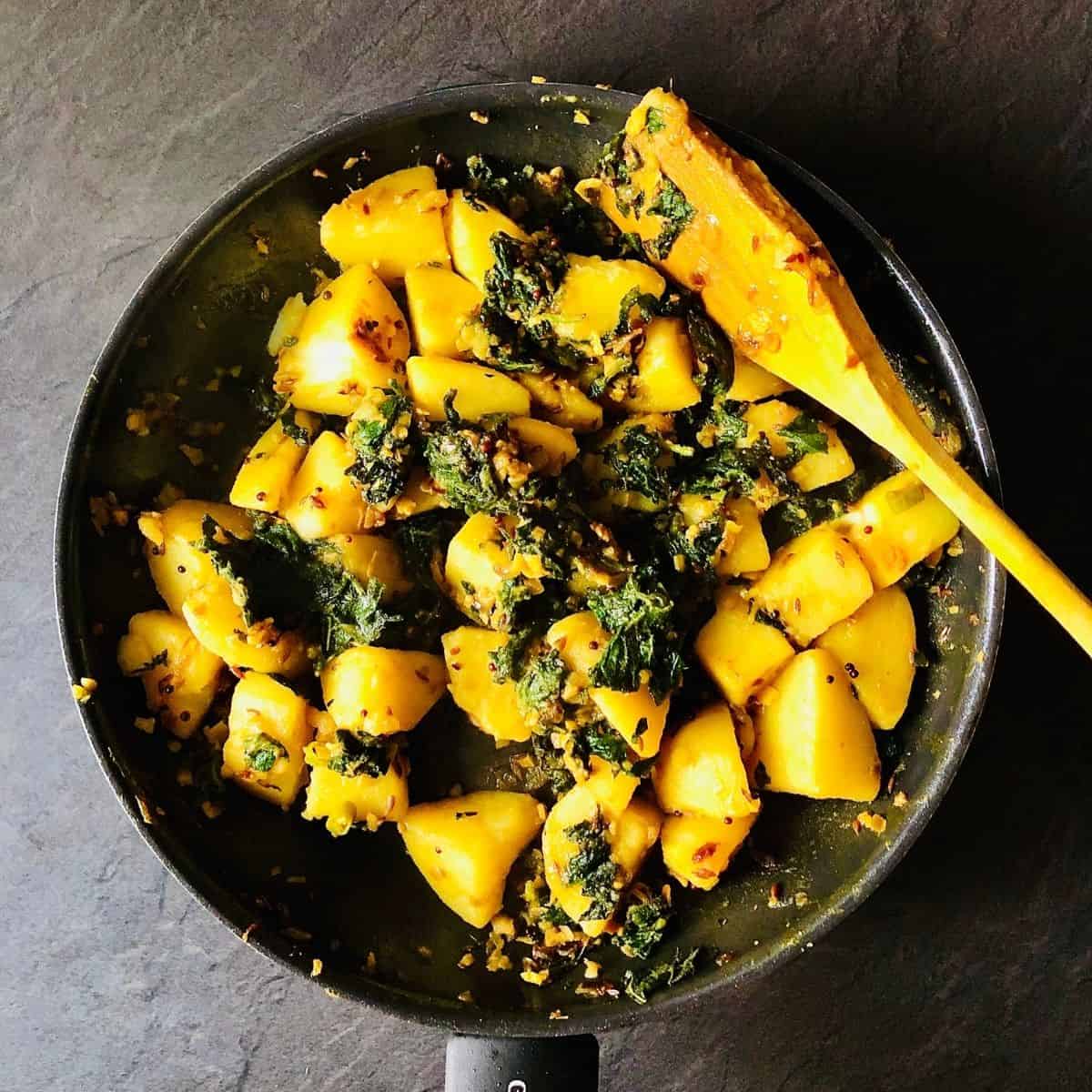 Frying pan containing saag aloo after cooking complete