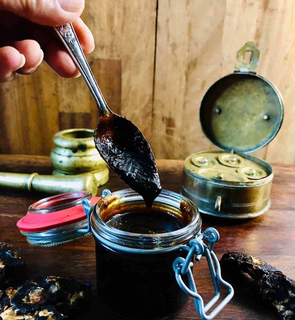 Sonth Ki Chutney pouring from a teaspoon held over a small jar of Sonth Ki Chutney