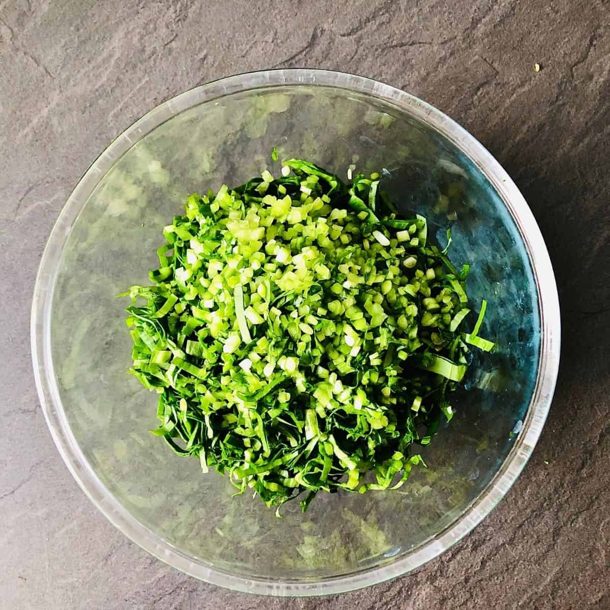 Glass bowl containing finely chopped wild garlic