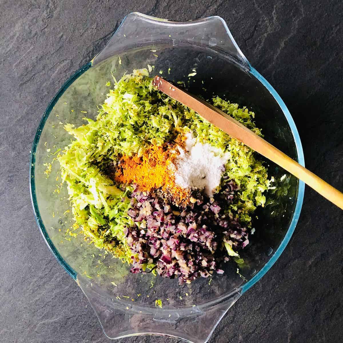 Ingredients for broccoli fritters in a glass bowl ready to mix together.