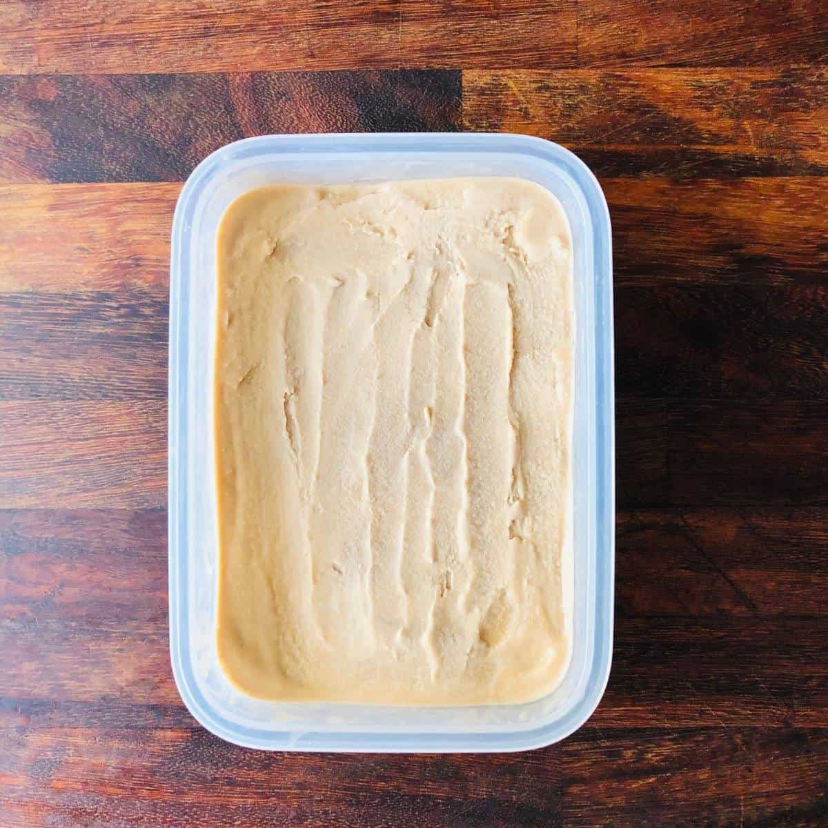 A plastic tub containing frozen coffee ice cream