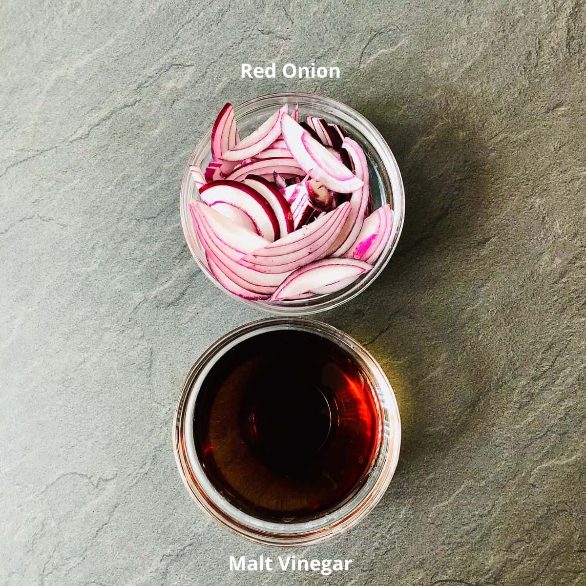 Ingredients for pickled red onion in small glass dishes. Sliced Red onion and malt vinegar