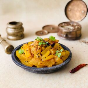 A shallow plate containingTarbooz Ki Sabzi, watermelon rind dish.