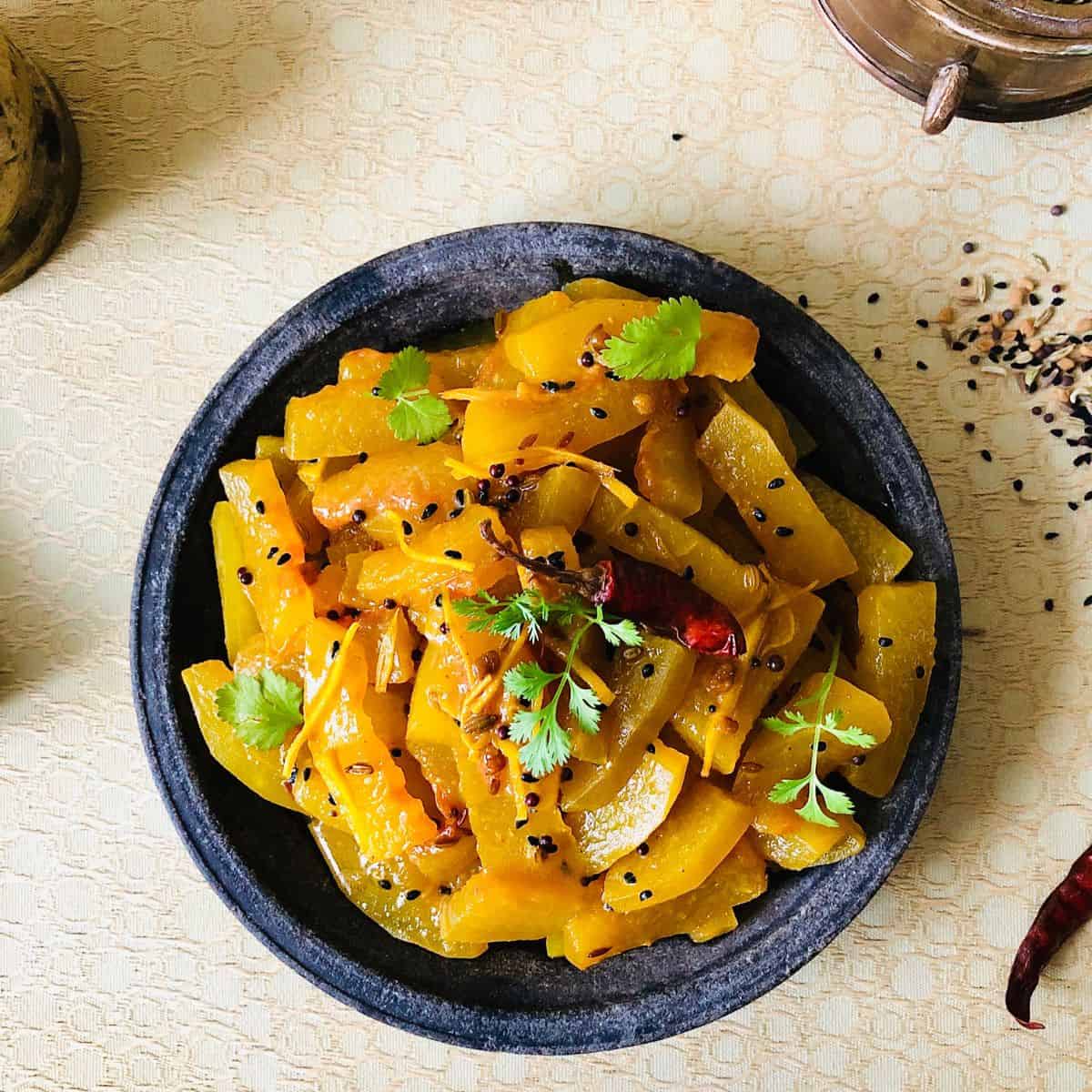 A shallow stoneware dish containing Tarbooz Ki Sabzi.