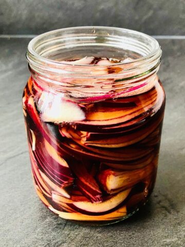 Close up of a jar of pickled red onion.