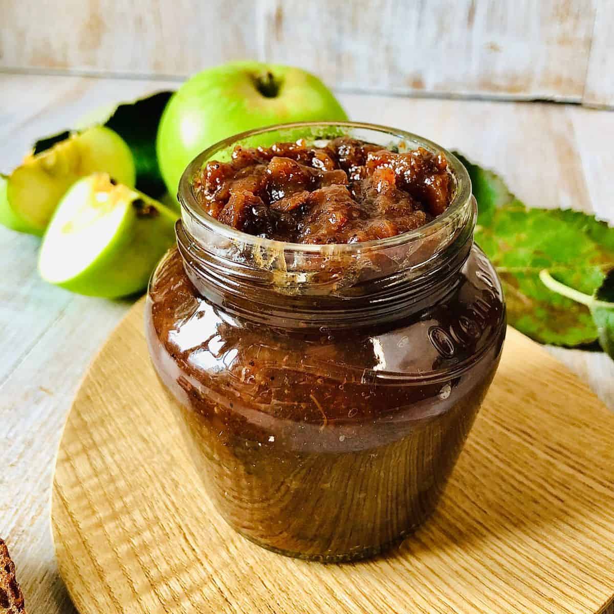 A small jar containing spiced apple and red onion chutney.