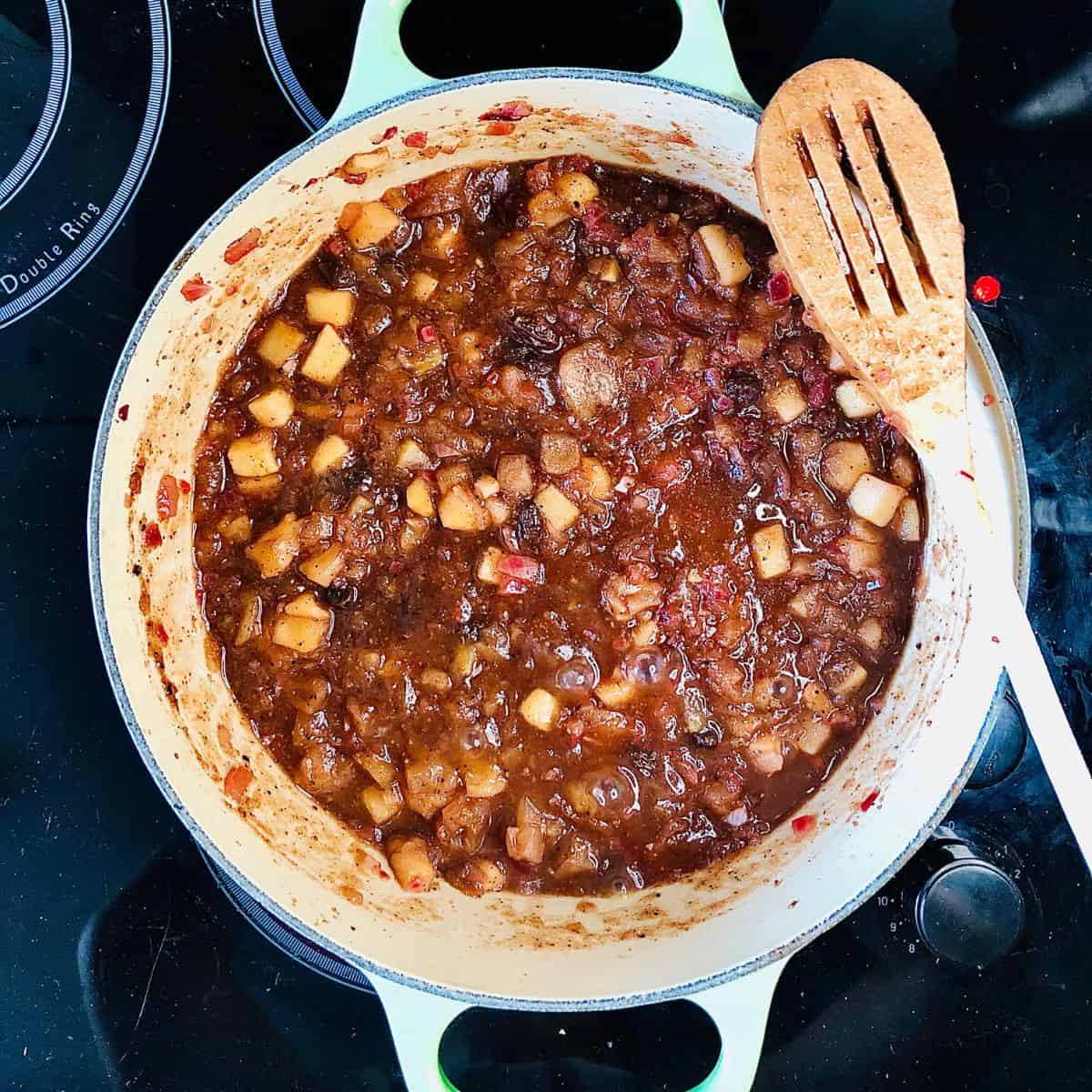 A large heavy duty pot containing partially cooked apple chutney.