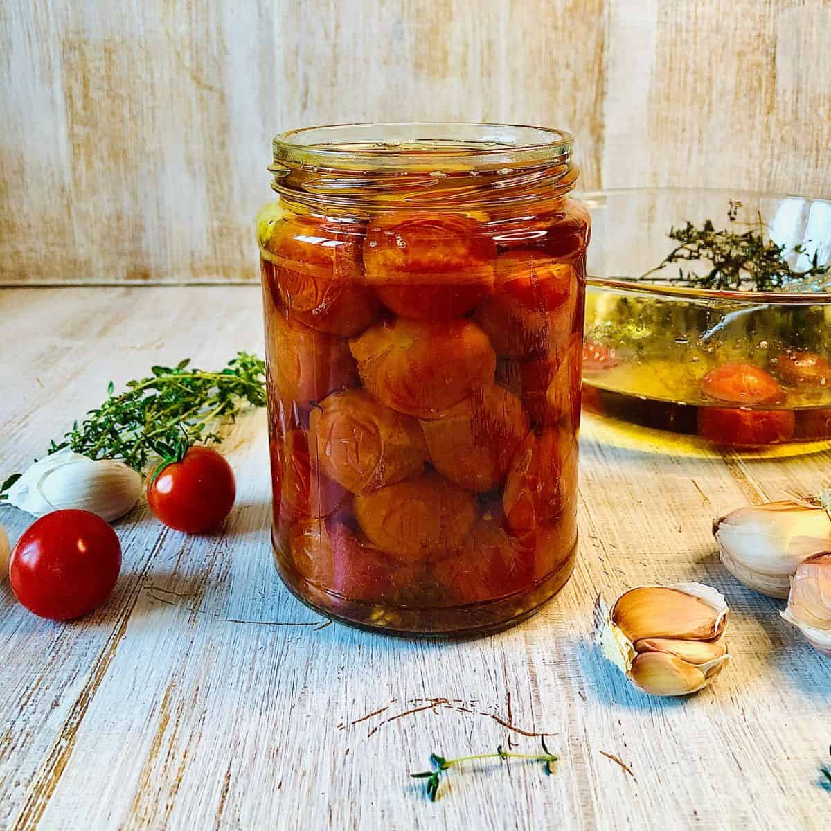 A jar containing confit cherry tomatoes.