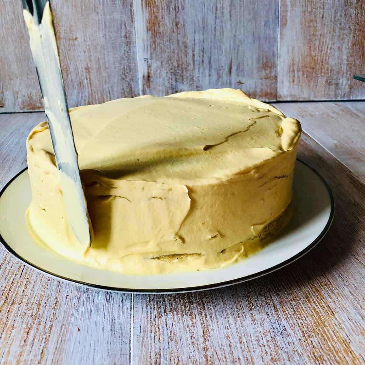 Vegan crepe cake with whipped vegan cream smoothed over the whole surface with a palette knife.